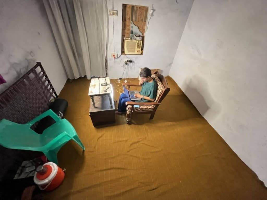 Haseeb working from a small room on a laptop, before copywriting changed his income.